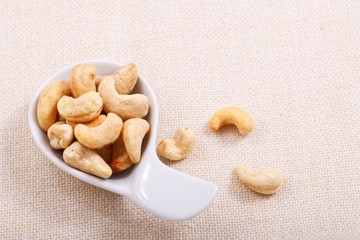 Organic raw Cashew nut in white ceramic bowl on base napkin