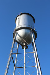Tall old style water tower against a deep blue sky
