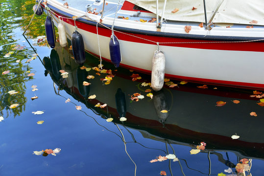 autunno parabordi della barca e fogli colorati sull'acqua