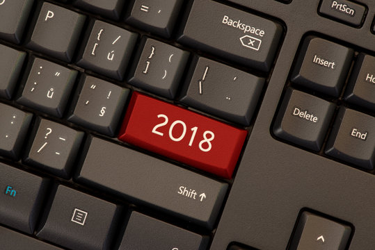Red button key with year 2018 concept on black keyboard