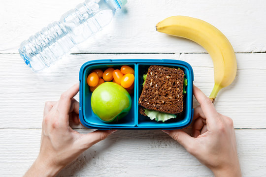 Image of man's hands with useful lunch in box
