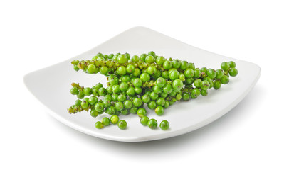 Bunches of fresh green peppercorn in a plate isolated on white background