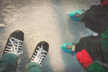 father and child learning to skate in winter