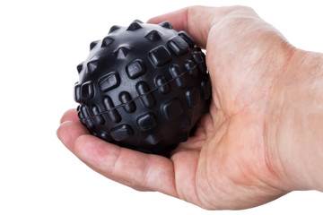 Hand holding a ball with spikes for myofascial massage. On white background.