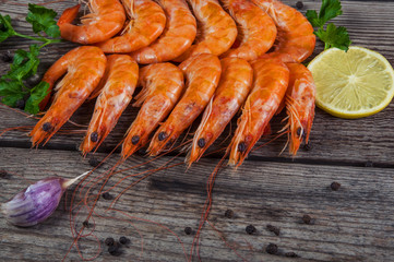 Selection of shrimps for dinner on wooden plate. Food background