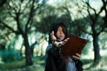 Image of witch with outstretched hand and book