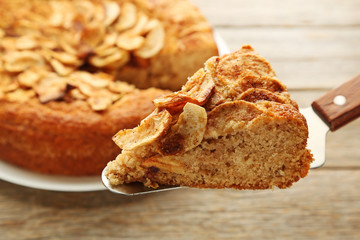 Slice of apple cake on grey wooden table