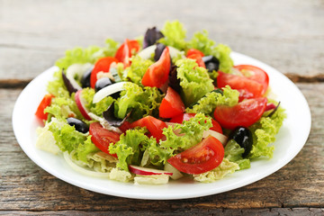 Vegetable salad in plate on wooden table