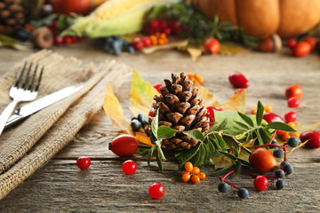 Autumn leafs with berries on grey wooden table
