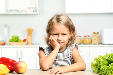 Little girl sitting in the kitchen