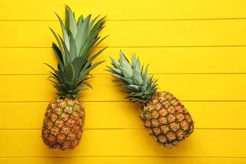  Ripe pineapples on yellow wooden table © 5second