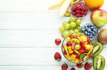Naklejka na ściany i meble Fruit salad in bowl on white wooden table