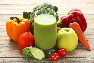 Vegetables smoothie in glasses on grey wooden table