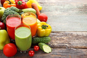 Vegetables smoothie in glasses on grey wooden table