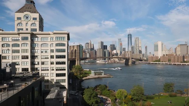 A daytime sunny establishing shot of the New York City skyline as seen from the Manhattan Bridge over the East River.  