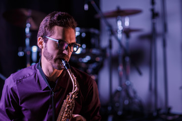 Close up portrait of saxophone player with drums on a background