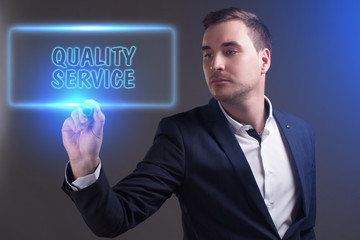 The concept of business, technology, the Internet and the network. Young businessman showing inscription: Quality service
