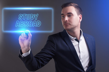 The concept of business, technology, the Internet and the network. Young businessman showing inscription: Study abroad