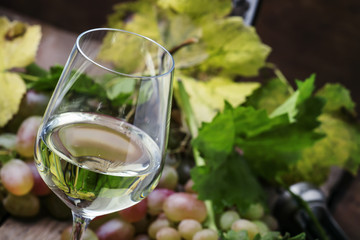 Dry white wine and grapes, vintage wooden background, selective focus