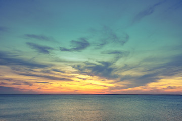 Fototapeta premium Aerial panoramic view of sunset over ocean. Nothing but sky, clouds and water. Dramatic picturesque evening scene. Ocean and colorful cloudy sky in the background. Nature landscape. Travel background