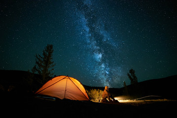 Man tourist near his camp tent at night. - 177120643