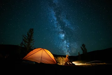 Foto op Plexiglas Man tourist near his camp tent at night. © tolstnev
