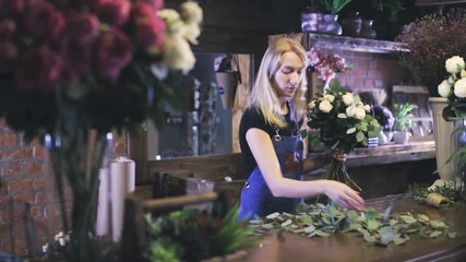 Female florist making bouquet at flower shop