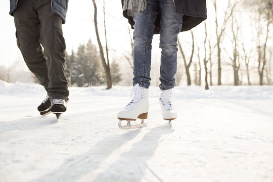 Close-up of two ice skaters on frozen lake