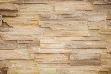 beige stone lined with granite walls, decorative exterior wall close up photo.