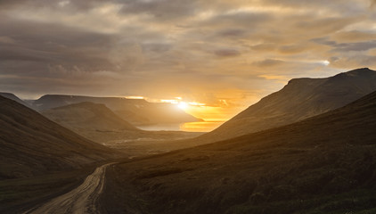 Fototapeta na wymiar Travel to Iceland. beautiful sunset over the ocean and fjord in Iceland. Icelandic landscape with mountains, sky and clouds.