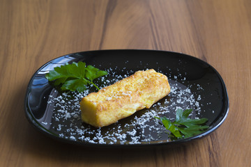 Crocchetta di patate con prezzemolo e formaggio grattato disposta su un piatto nero