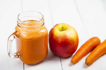 Apple-carrot juice on a  wooden table.