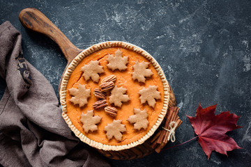 Obraz na płótnie Canvas Pumpkin pie with pecan nuts on stone background and copy space for text. Table top view. Thanksgiving day food