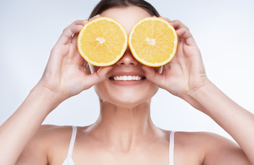 Woman closing eyes with lemons
