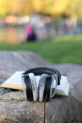 Kopfhörer auf einem Buch - Assoziation: Hörbuch, Hörbücher, Audiobook
