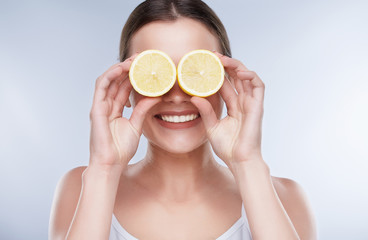 Woman closing eyes with two lemons