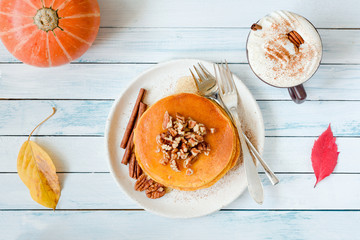 Pumpkin pancakes with pecan nuts and honey and pumpkin spice latte in cup. Top view © Vladislav Noseek
