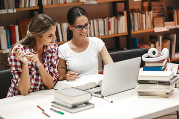Two female students study in the school library.Learning and preparing for university exam.