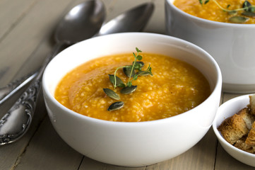 Vegetarian pumpkin soup on a wooden table.