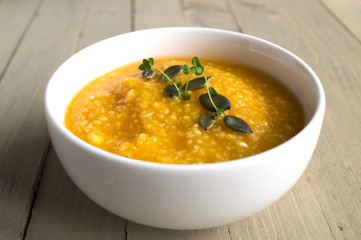 Vegetarian pumpkin soup on a wooden table.