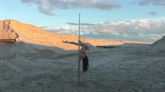 Woman trains to dance on a pole, she is an actor aerial acrobat.
