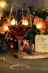 Cheese roquefort with figs,nuts  and a wineglass of red wine on a wooden background