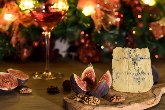Cheese roquefort with figs,nuts  and a wineglass of red wine on a wooden background
