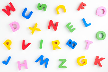 Background of multicolored wooden letters of the English alphabet on a white background. Effective material for teaching children alphabet. Background for your text and design             