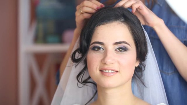 Young brunet bride. Applying wading makeup