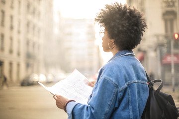 Girl walking around the city with a map in her hands