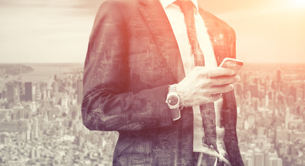 Double exposure of success business man with smart phone and city in background. Concept businessman lifestyle