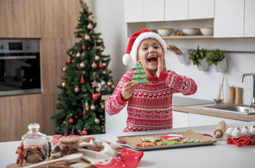 Obraz na płótnie Canvas Joyful little girl having fun in kitchen on holiday