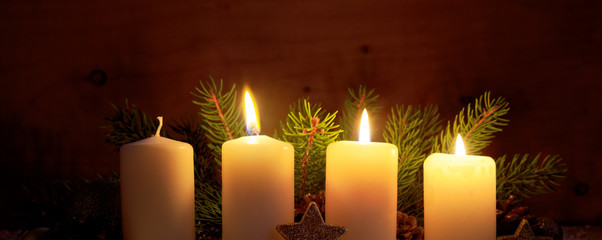 Three burning advent candles and Christmas decoration.