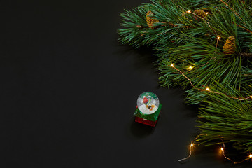 Christmas. Xmas toys and spruce branch on black background top view. Space for text